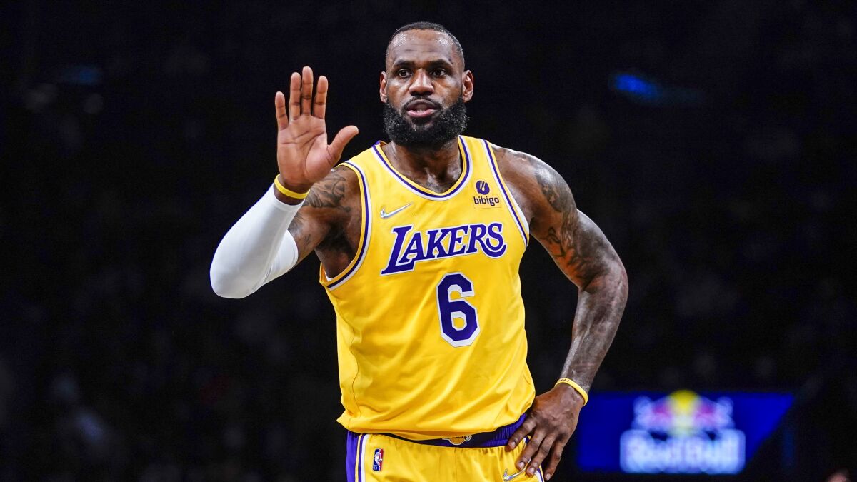Los Angeles Lakers forward LeBron James holds up his hand 
