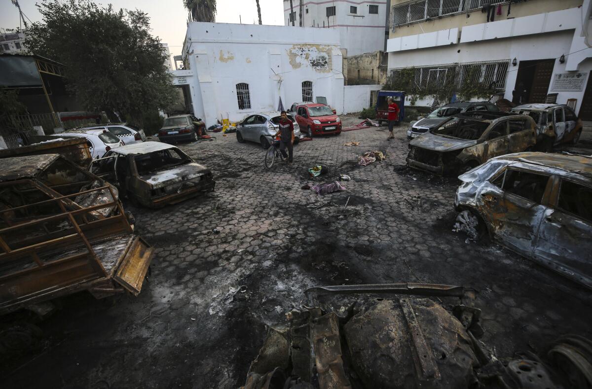 Burned-out vehicles sit on scorched ground.