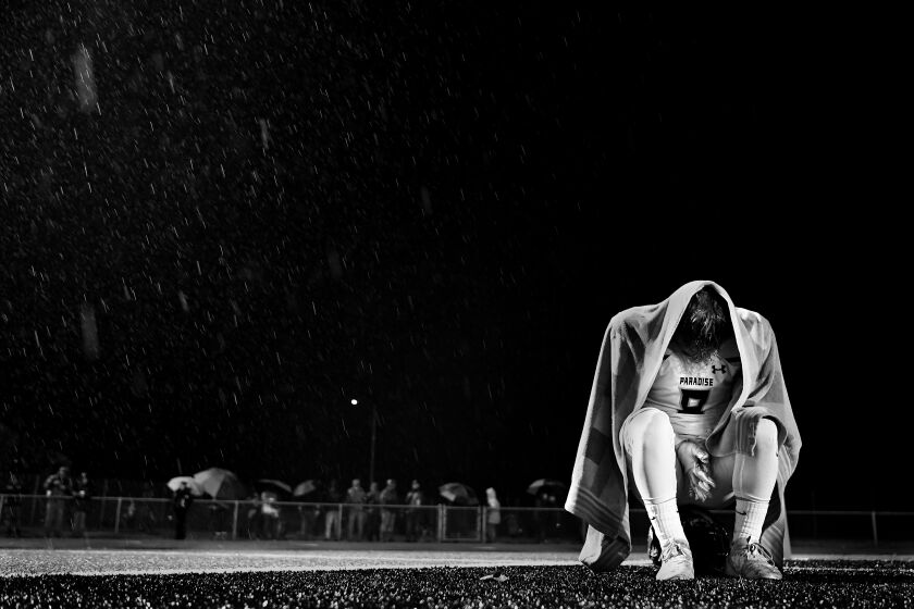 YUBA CITY, CALIFORNIA NOVEMBER 30, 2019-Paradise High School football player Brenden Moon sits alone in the end zone while rain comes down as the Bobcats lose the sectional championship in Yuba City, California Saturday. Brenden lost his home to the Camp Fire last year and lost his mother to suicide during the football season. (Wally Skalij/Los Angerles Times)