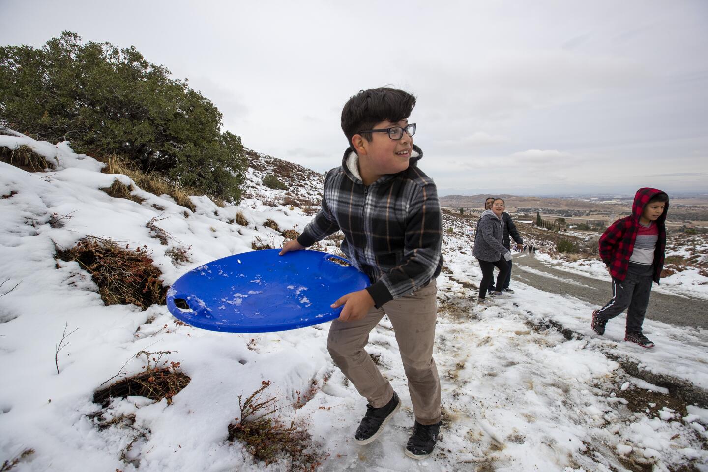 Felix Gonzalez, 10, plays in the snow lingering on Tierra Subida Ave. in the Antelope Valley town of Palmdale in Palmdale, Calif., on Dec. 1, 2019.