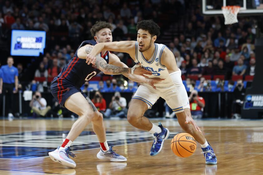 UCLA guard Johnny Juzang, right, drives around St. Mary's guard Logan Johnson (0) during the first half of a second-round NCAA college basketball tournament game, Saturday, March 19, 2022, in Portland, Ore. (AP Photo/Craig Mitchelldyer)