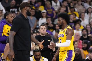 Los Angeles Lakers' LeBron James, left, greets his son, Bronny James as Bronny comes off the court during the first half of a preseason NBA basketball game, Friday, Oct. 4, 2024, in Palm Desert, Calif. (AP Photo/Mark J. Terrill)