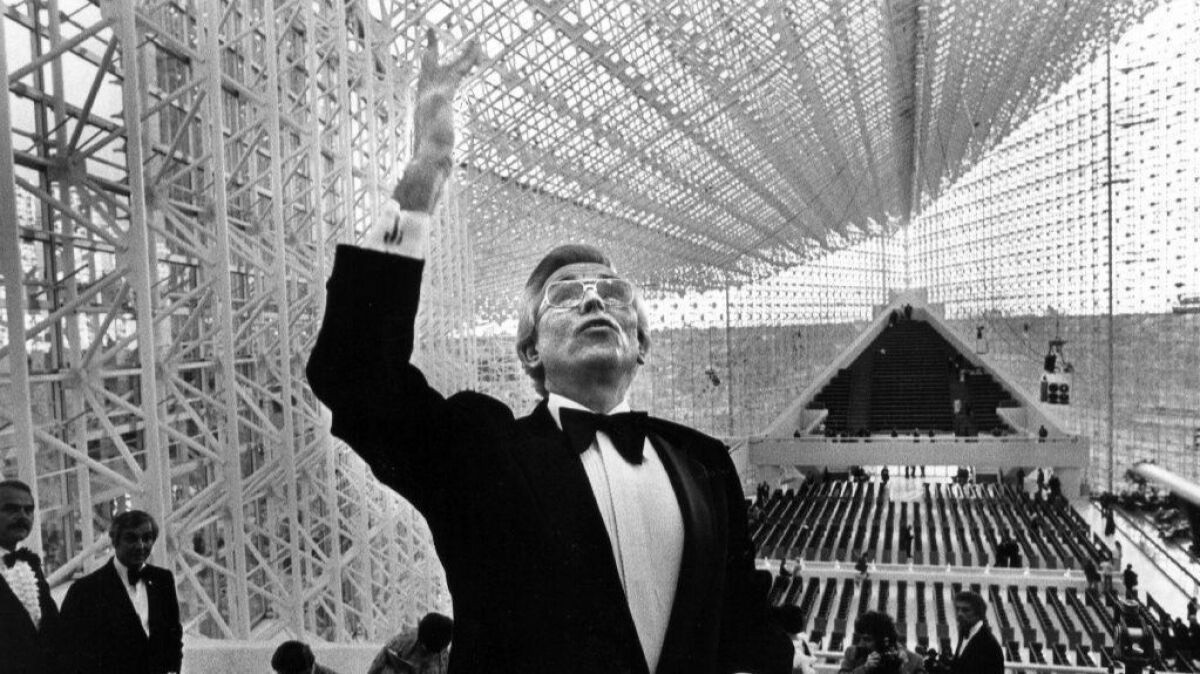 The late televangelist Robert Schuller conducts a pre-concert tour of the new Crystal Cathedral on May 14, 1980.