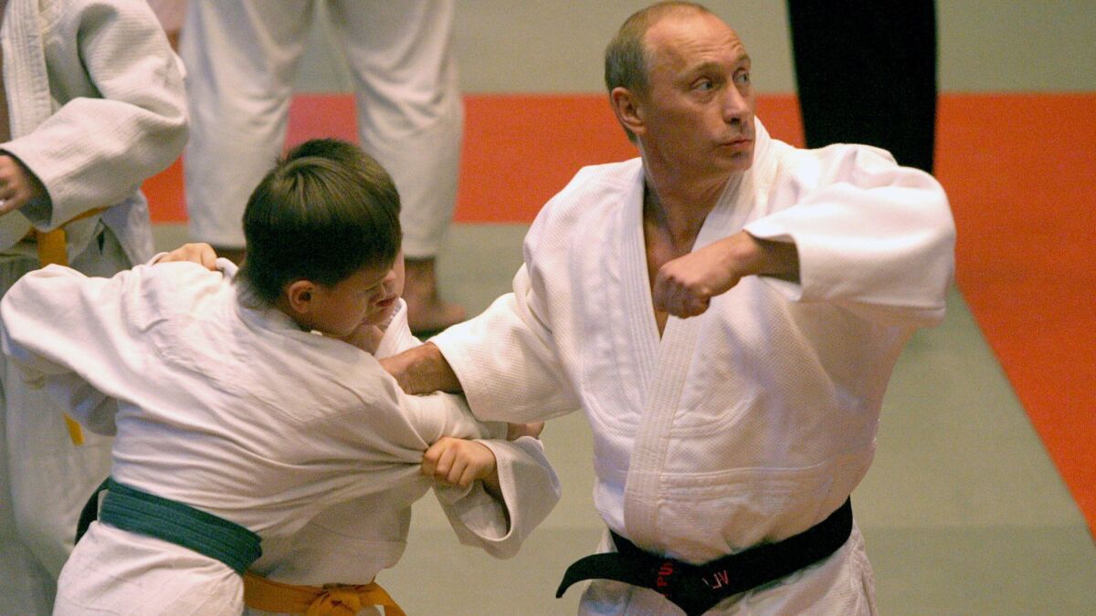 Presiden Rusia Vladimir Putin mendemonstrasikan keterampilan judonya pada seorang siswa muda selama kunjungannya ke sekolah olahraga di St. Petersburg pada 24 Desember 2005.