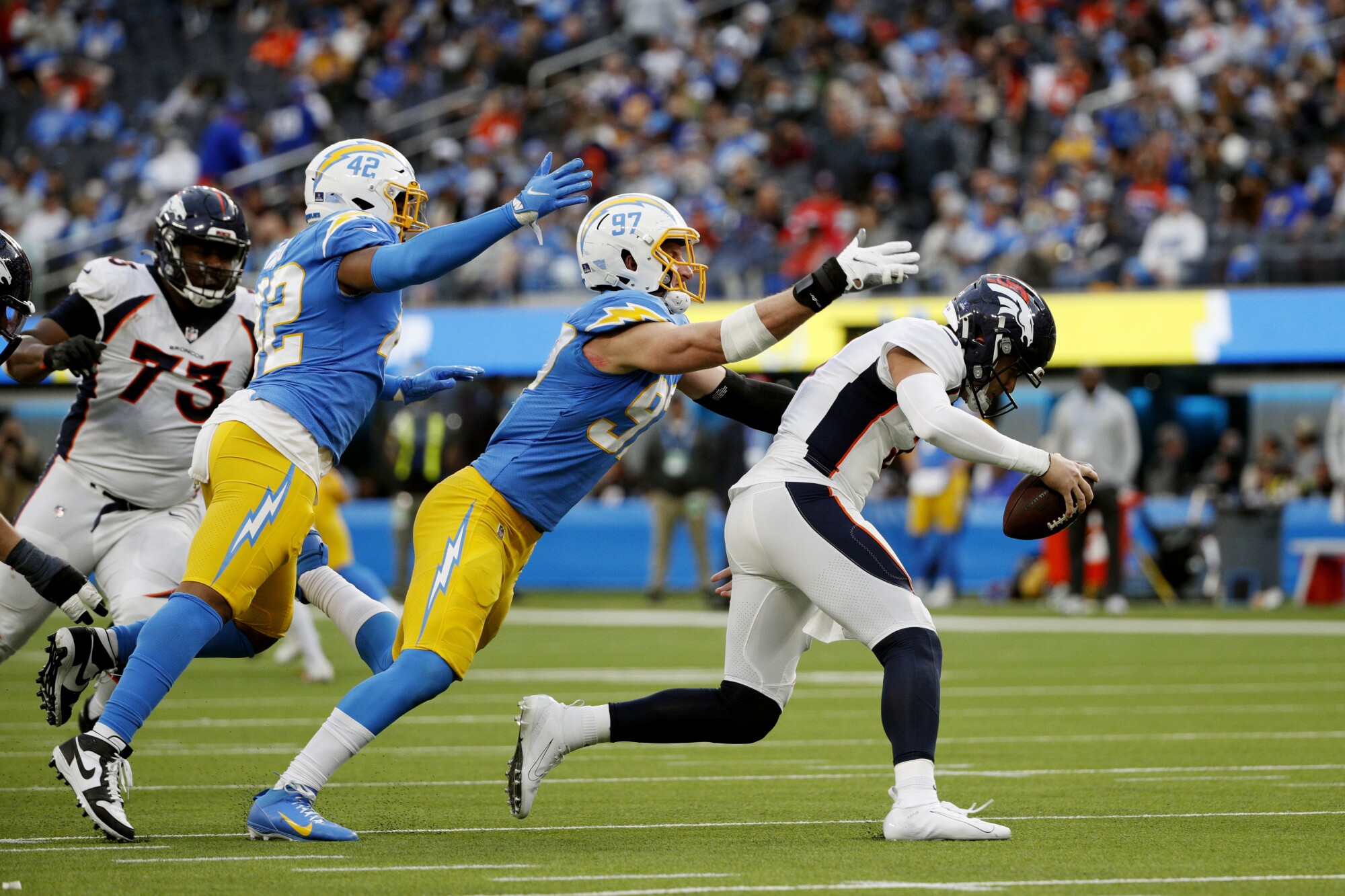 Chargers linebacker Uchenna Nwosu and defensive end Joey Bosa lunge to sack Denver Broncos quarterback Drew Lock.