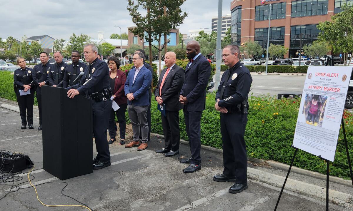 Los Angeles Police Department Chief Michel Moore, at podium, addresses reporters.