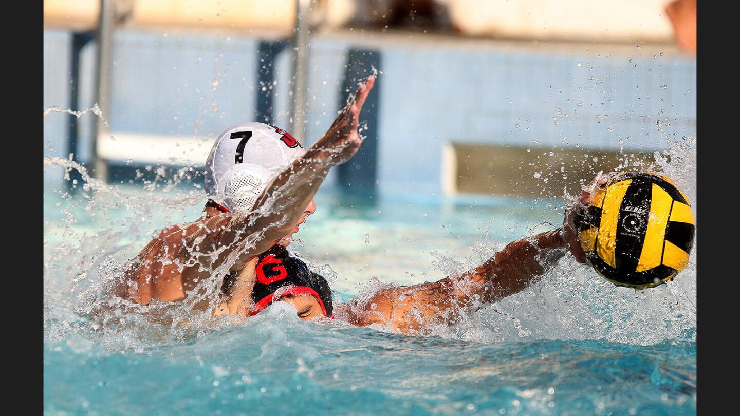 Burroughs' David Arakelyan defends against Glendale's Michael Georgizian who is protecting the ball in a Pacific League boys' water polo match at Glendale High School on Tuesday, October 10, 2017. Burroughs won the match 18-13.