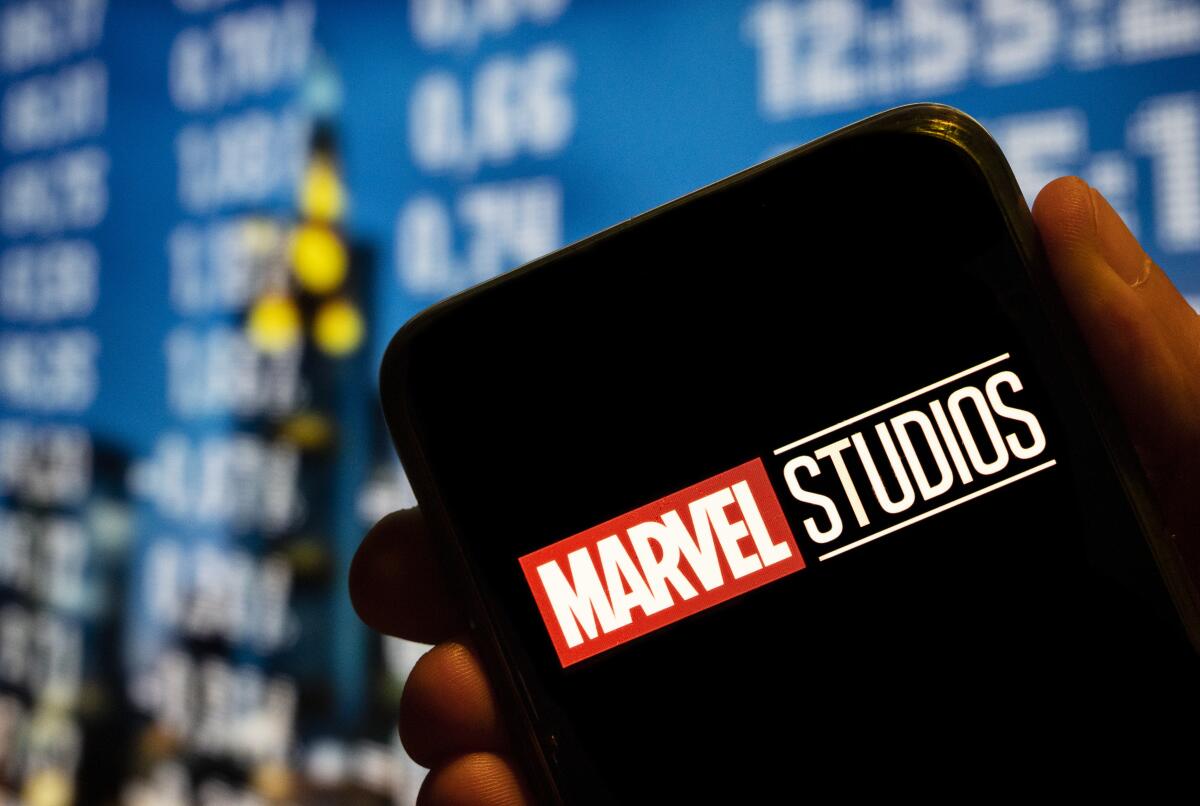 The Marvel Studios logo is displayed on a smartphone screen.