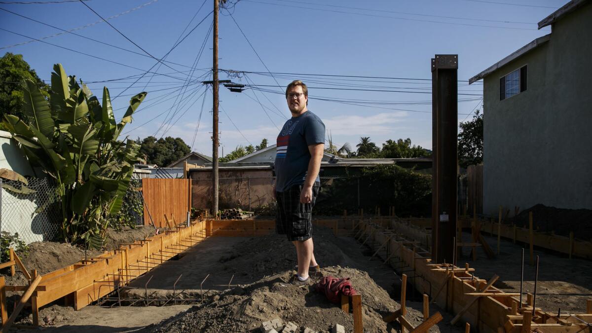 John Gregorchuk stands amid construction of a secondary dwelling unit that has been stalled in his backyard in Los Angeles.