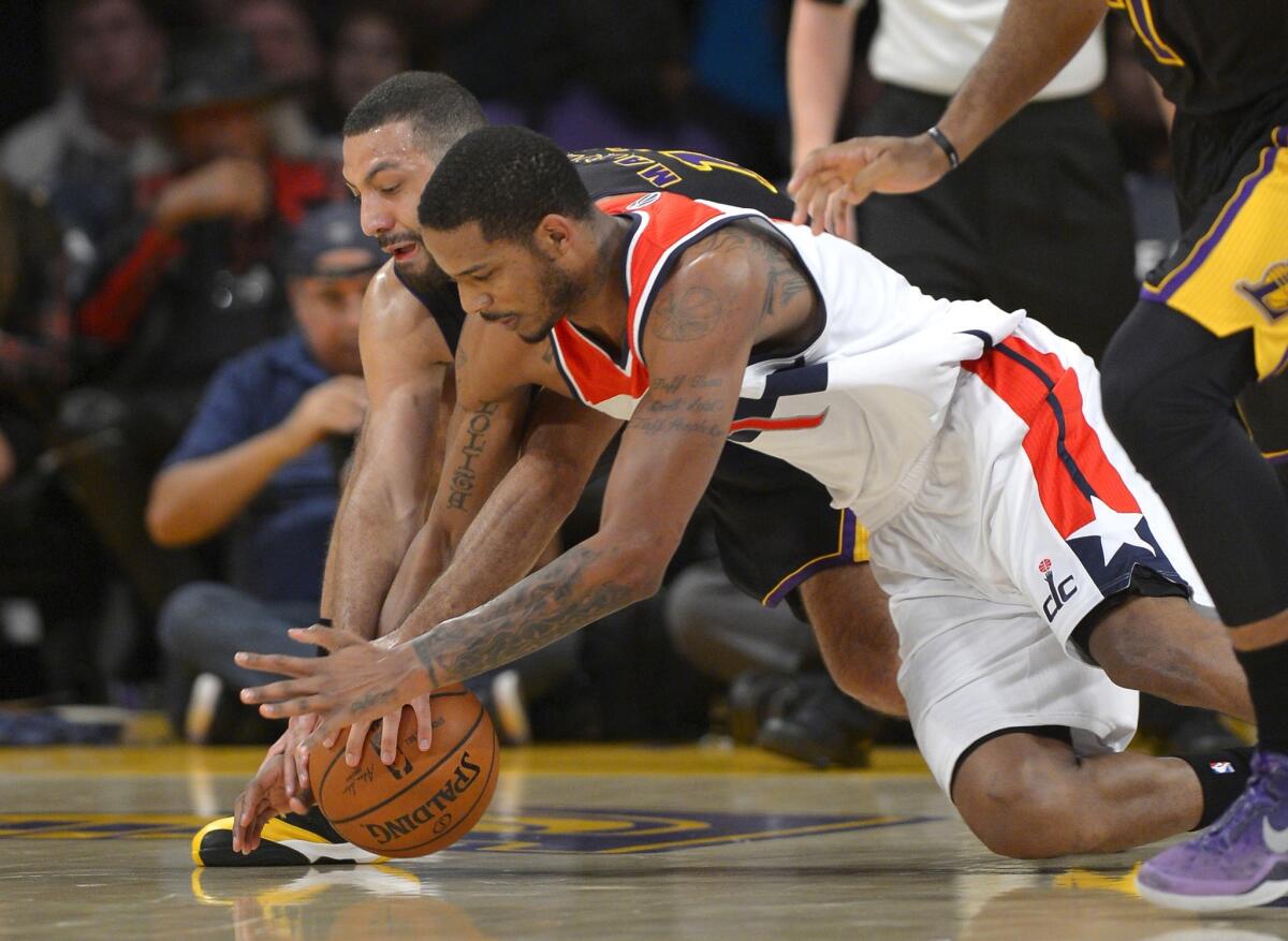 Trevor Ariza and Kendall Marshall chase a loose ball during the first half of a game on March 21. Ariza was traded to the Houston Rockets by the Washington Wizards as part of a three-team deal also involving the New Orleans Pelicans.