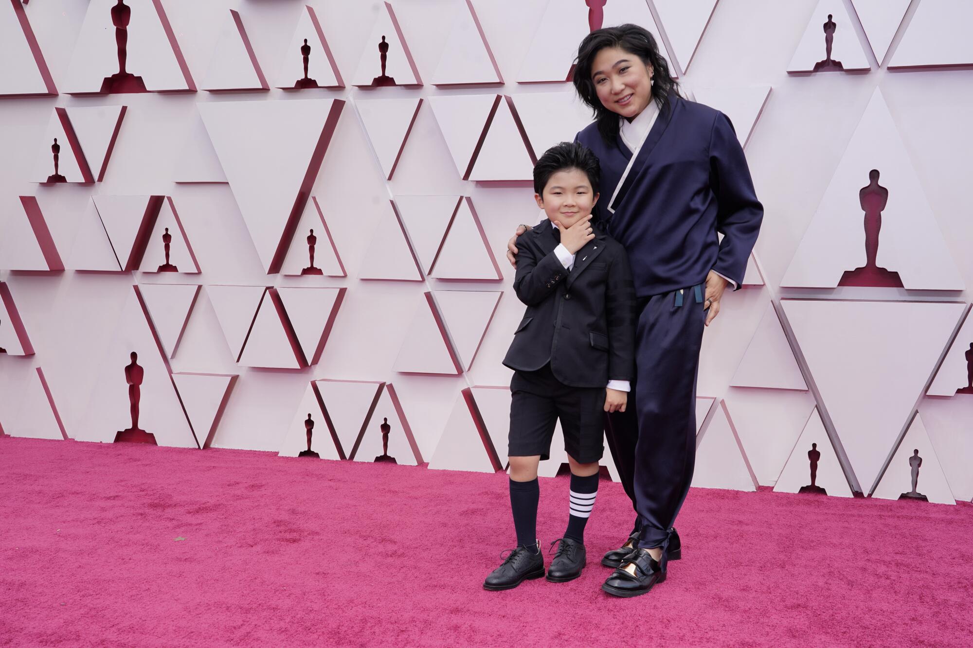 Alan Kim in short pants and "Minari" producer Christina Oh in a dark pantsuit. 