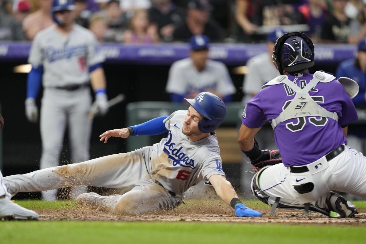 Trea Turner scores as Rockies catcher Elias Diaz turns to apply a tag in the fourth inning.