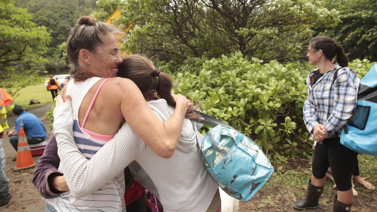 Beaux Birch, left, hugs friend Diana Penchoff on April 17 in Haena, Kauai, before being evacuated by a U.S. Army helicopter.