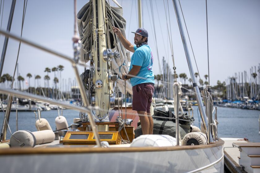 Long Beach, CA - July 14: Ben Wheatley, head rigger, Bahia Marine, who's family business can't find employees to work, hoists a sail onboard the Chubasco, a Sparkman & Stephens 67' sailboat built in 1939 in Alamitos Bay Marina in Long Beach and hasn't really had time off since the pandemic begun Wednesday, July 14, 2021. (Allen J. Schaben / Los Angeles Times)