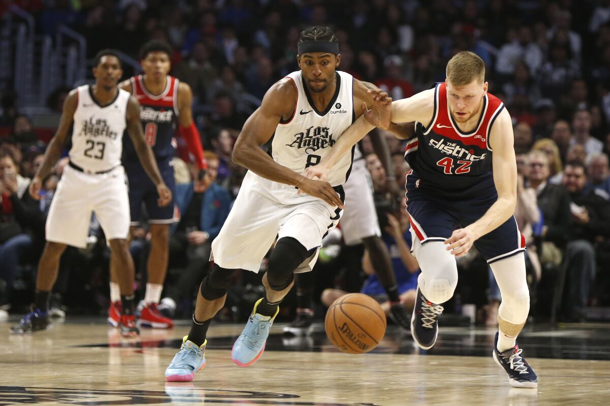 Clippers forward Maurice Harkless, left, battles Washington Wizards forward Davis Bertans for control of the ball.