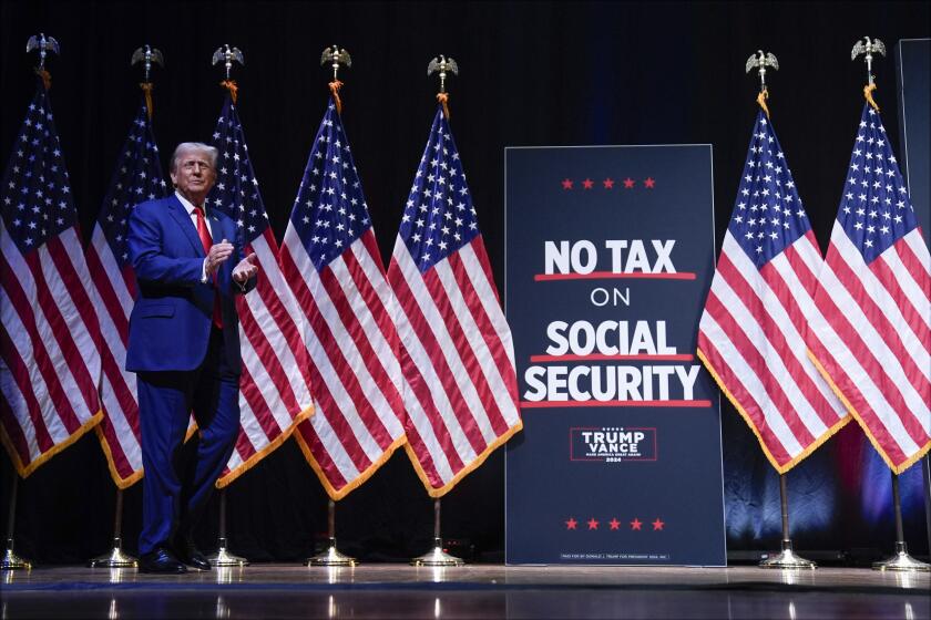 El candidato presidencial republicano Donald Trump aplaude a su llegada a un mitin de campaña, el miércoles 14 de agosto de 2024, en Asheville, Carolina del Norte. El letrero dice: "No al impuesto al seguro social". (AP Foto/Matt Rourke)