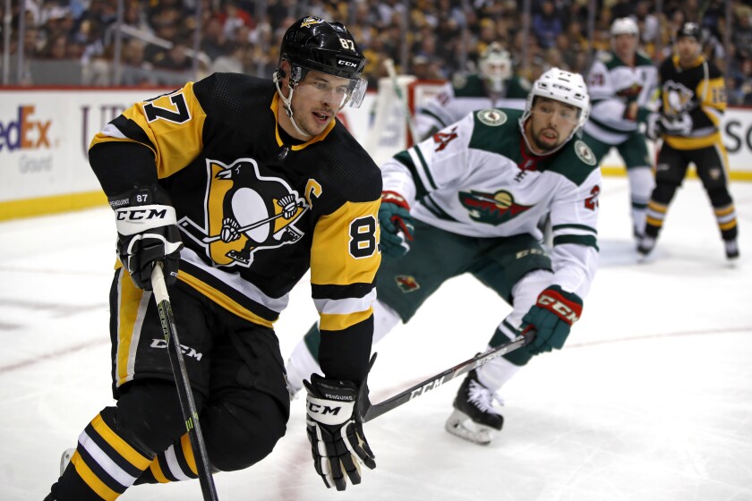 Pittsburgh Penguins' Sidney Crosby (87) works the puck in the corner with Minnesota Wild's Matt Dumba (24) defending during the second period of an NHL hockey game in Pittsburgh, Tuesday, Jan. 14, 2020. (AP Photo/Gene J. Puskar)