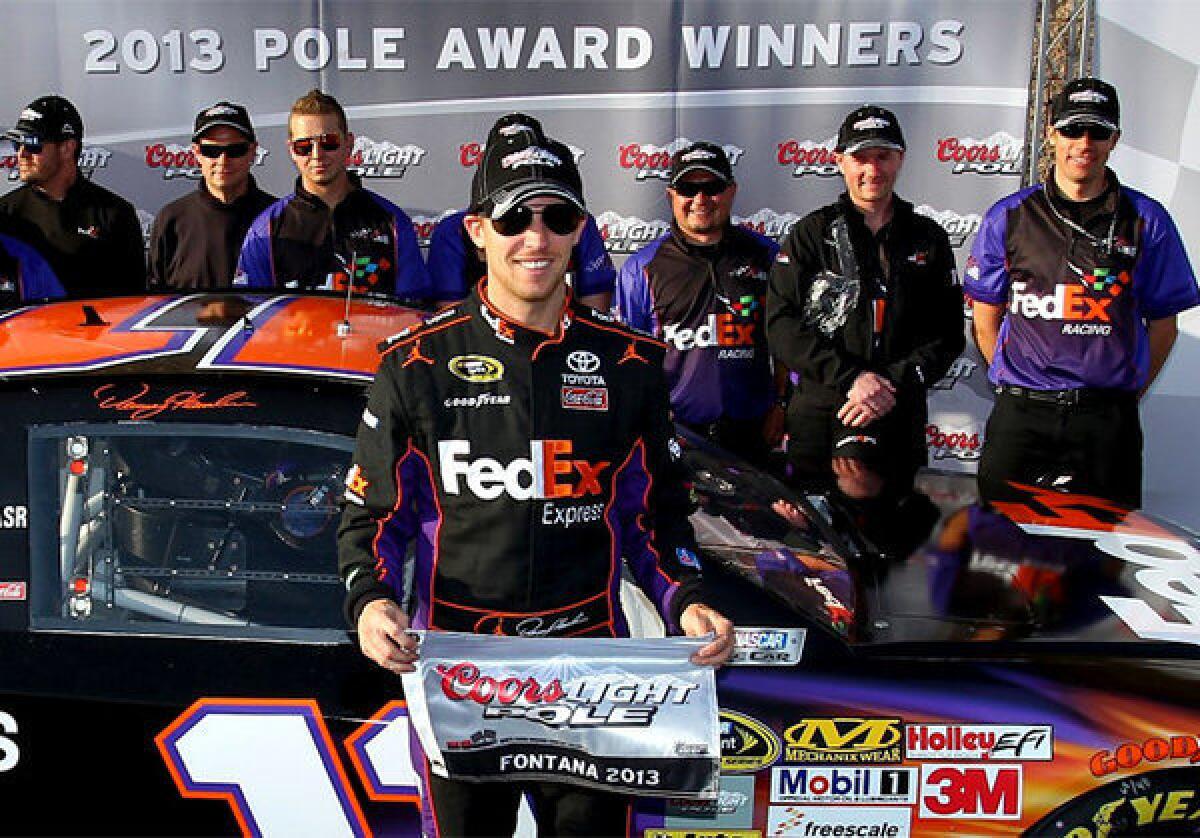 Denny Hamlin poses after qualifying for the pole position in the NASCAR Sprint Cup Series Auto Club 400.
