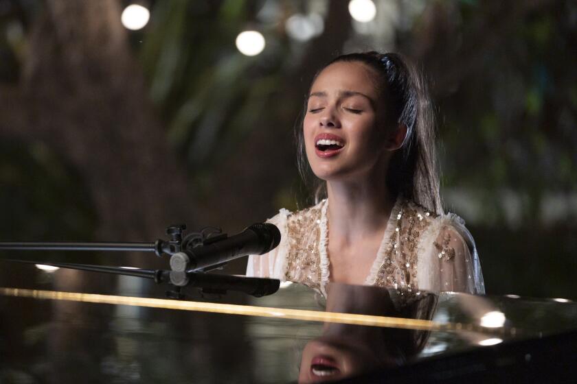 Olivia Rodrigo singing at a piano