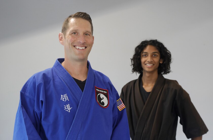 Master Jeff Kash, a sixth-degree black belt, left, stands with star student Loki Mansukhani.