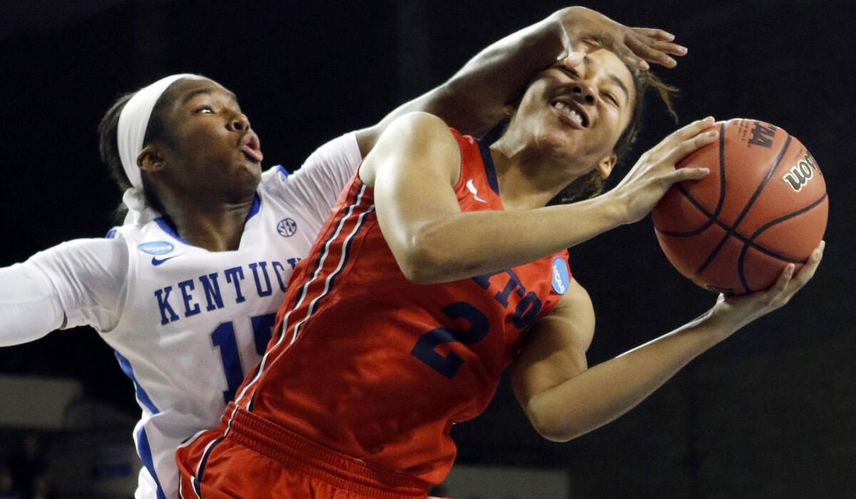 Dayton guard Amber Deane is guarded rather closely by Kentucky guard Linnae Harper in the first half of their NCAA tournament game on Sunday.