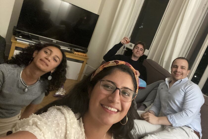 This image provided by Catalina María Gomez Caycedo shows Aleena Rupani, from left, Catalina María Gomez Caycedo, Henry Crabtree, and Michael Watkins in Crabtree's London flat. The close friends met through their work at a software company with workers scattered around the globe. A recent Gallup survey says just 2 in 10 adult U.S. employees say they have a best friend at work. (Catalina María Gomez Caycedo via AP).