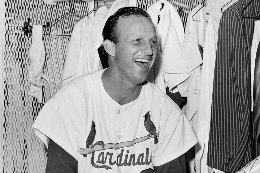 FILE - In this May 2, 1963, file photo, St. Louis Cardinals' Stan Musial sits in the clubhouse after he tied Babe Ruth's extra-base-hit record, against the Chicago Cubs in St. Louis. Fans of Cardinals great Stan Musial will get a chance to own a piece of his personal collection _ items ranging from game-worn jerseys to championship rings to harmonicas _ through an online auction that's now under way. Musial died in January at age 92. (AP Photo/File)
