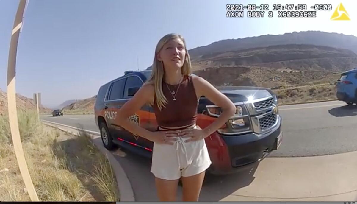 FILE- In this image taken from police body camera video provided by The Moab Police Department, Gabrielle "Gabby" Petito talks to a police officer after police pulled over the van she was traveling in with her boyfriend, Brian Laundrie, near the entrance to Arches National Park on Aug. 12, 2021. The family of Petito filed a notice of claim Monday, Aug. 8, 2022, of plans to file a wrongful death lawsuit against the tourist town of Moab, Utah, over police officers' handling of an encounter with Petito and her boyfriend weeks she was found dead in Wyoming. (The Moab Police Department via AP, File)