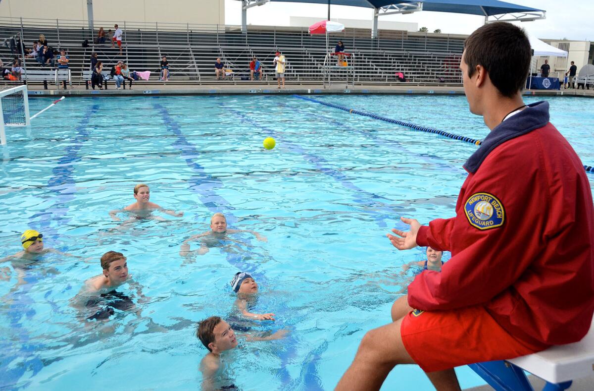 Lifeguard Ryan Paul tosses a ball to the junior lifeguard contenders to help take their minds off the 3 minute treading water test during the final tryouts held Sunday.