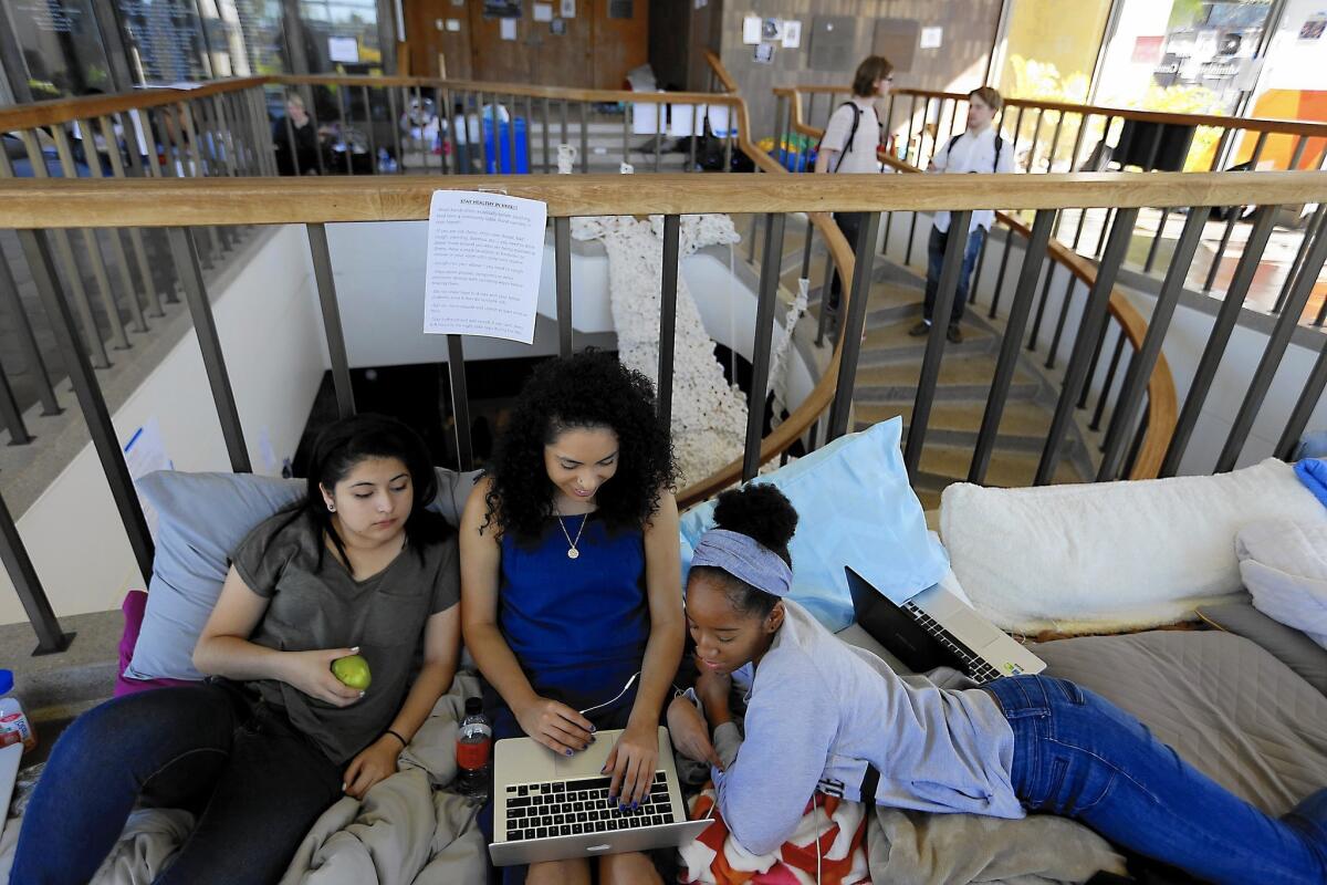 Mariel Guido, 18, left, Melissa Morales, 19, middle, and Nasira Pratt, 18, work on homework in the lobby of Occidental College's administration building. Students are occupying Arthur G. Coons Hall to protest the school's handling of diversity issues.