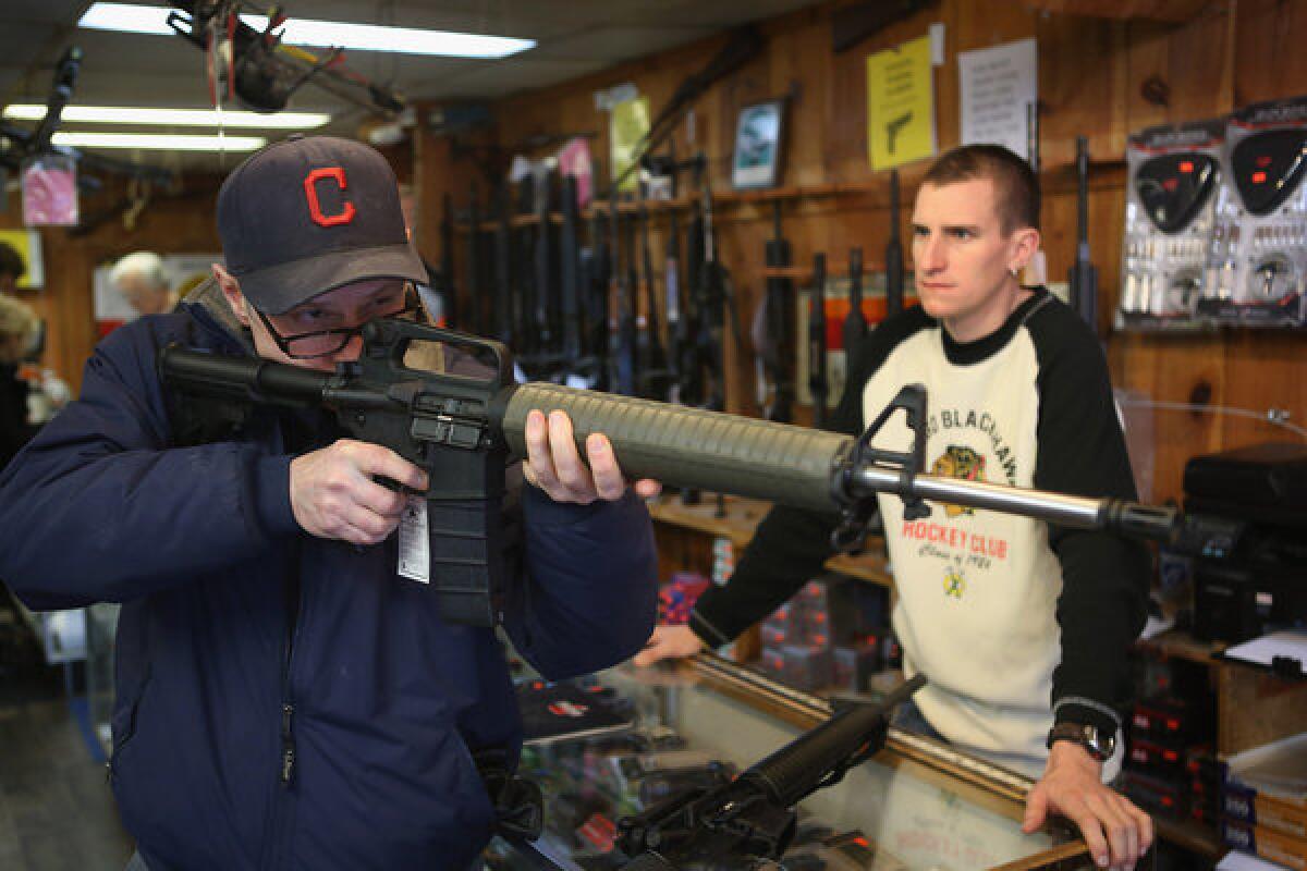 A customer selects a rifle at Freddie Bear Sports sporting goods store in Tinley Park, Ill.
