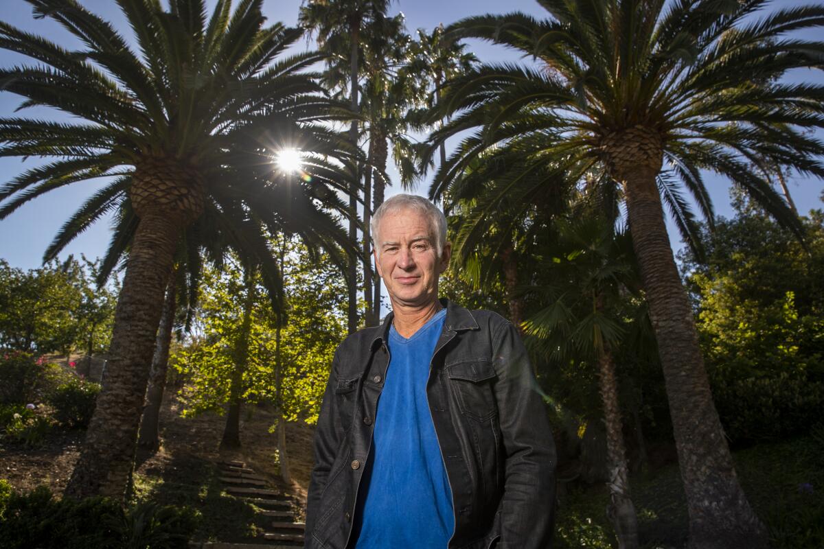 John McEnroe is photographed among palm trees at the Malibu Racquet Club.