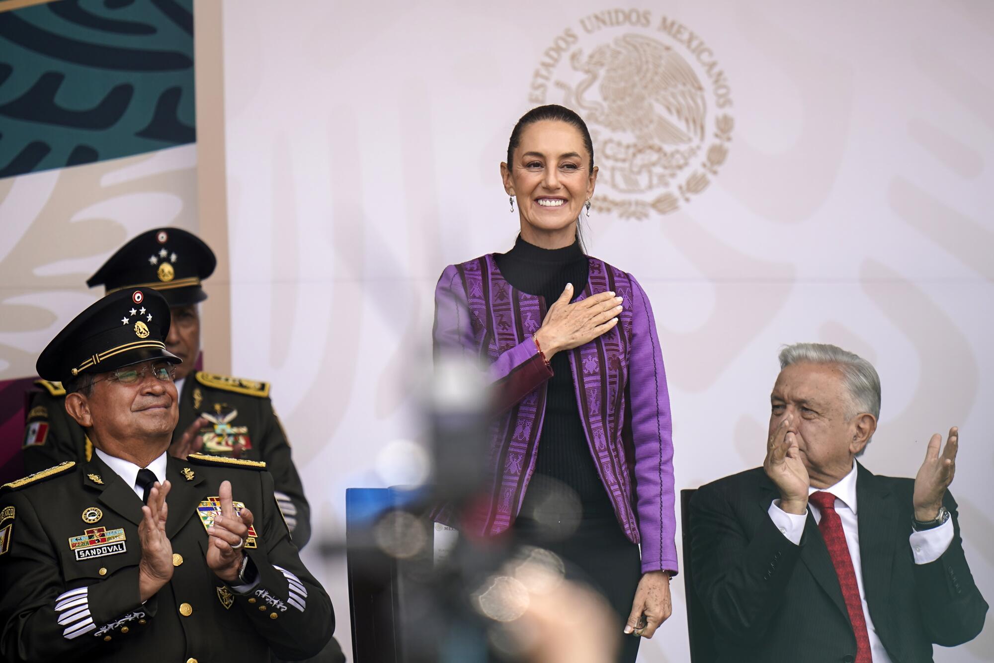 Mexican President-elect Claudia Sheinbaum smiles with her right hand over her heart during a ceremony