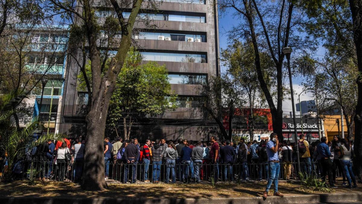 People wait on the streets in Mexico City after an earthquake in southern Chiapas state shook buildings in the capital, whose lake-bed soil amplifies the effects of even faraway quakes.