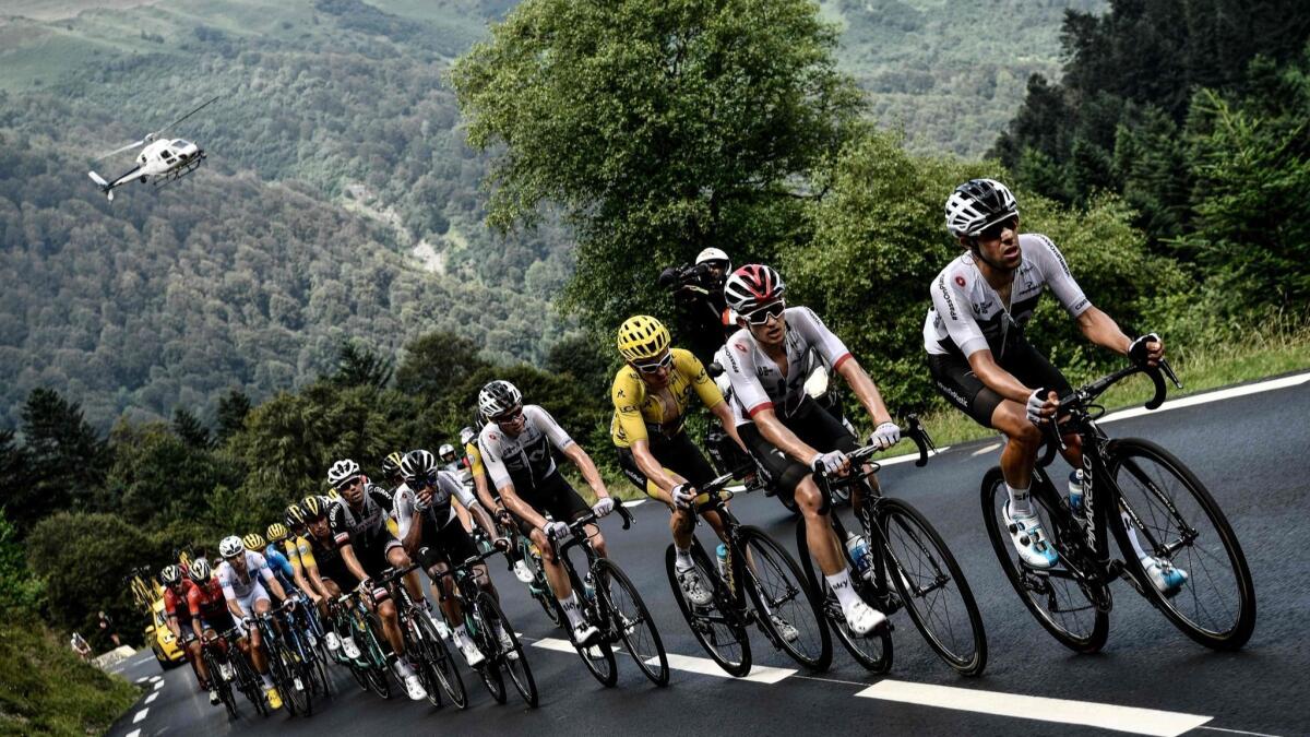 Geraint Thomas, wearing the Tour de France overall leader's yellow jersey, ascends with the pack on the Col du Tourmalet pass on July 27.