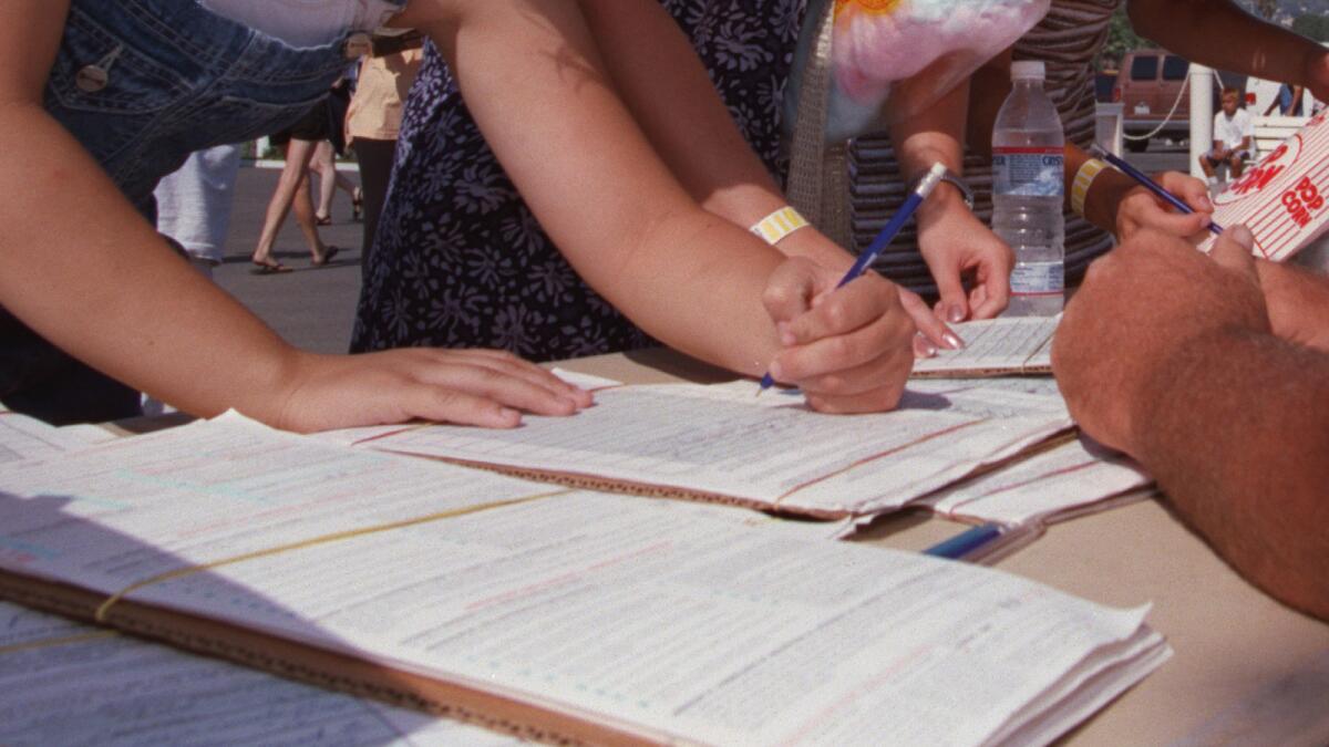 A file photo of voters signing a petition to put an initiative on California's ballot.