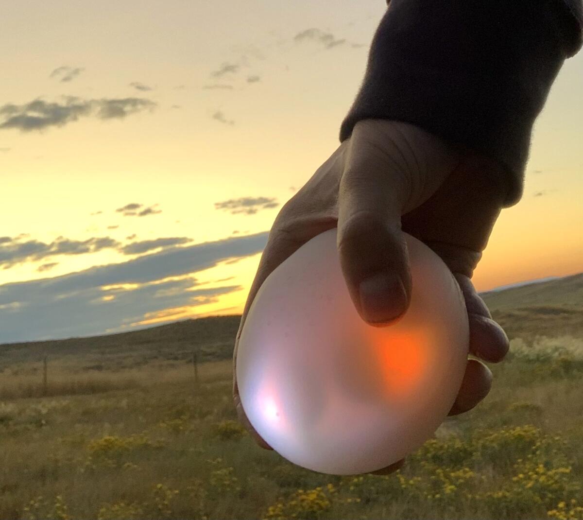 A man holds a glowing digital music player.