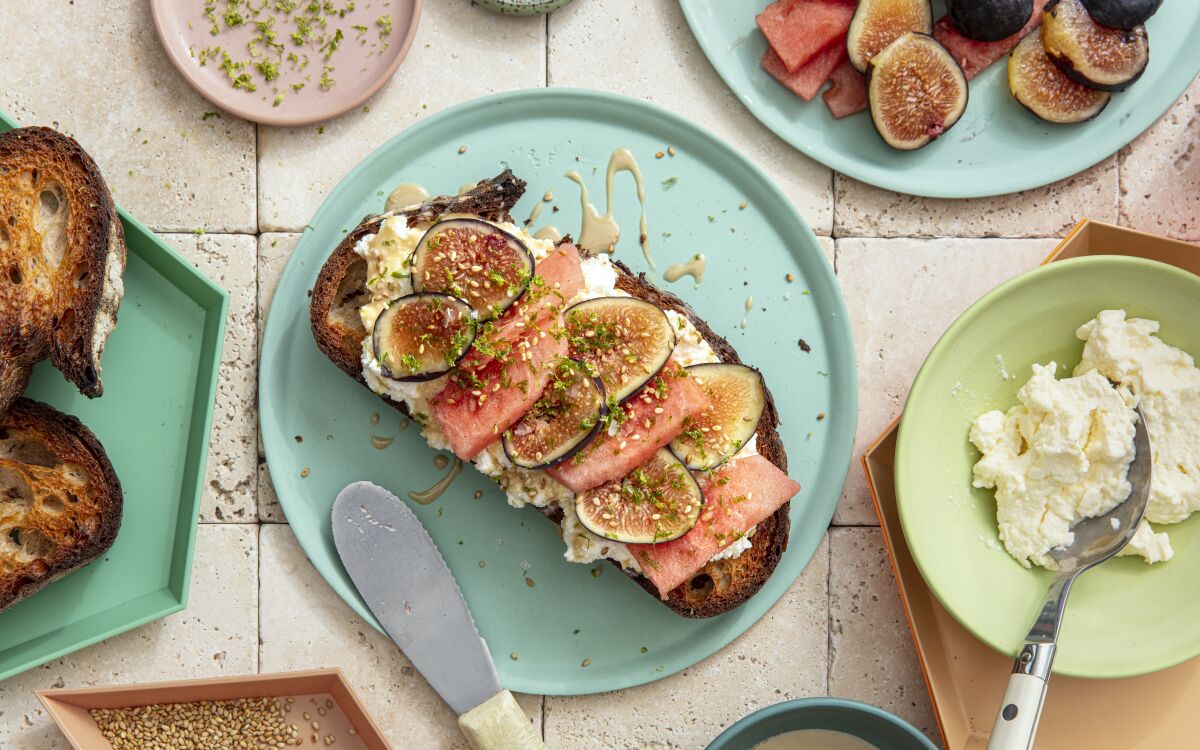 Rich figs and lean watermelon balance each other on this simple toast topped with tahini, sesame seeds and lime zest.