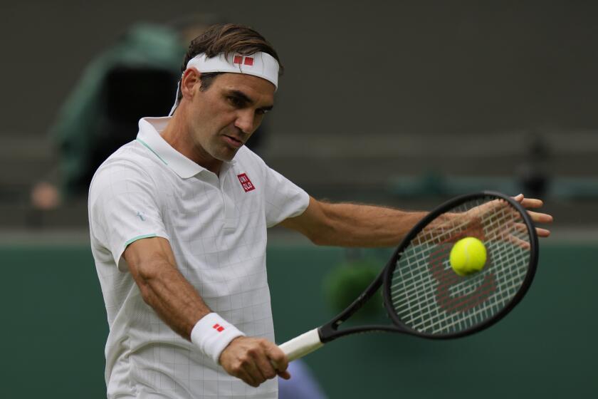 Switzerland's Roger Federer plays a return during the men's singles third round match against Britain's Cameron Norrie on day six of the Wimbledon Tennis Championships in London, Saturday July 3, 2021. (AP Photo/Alastair Grant)