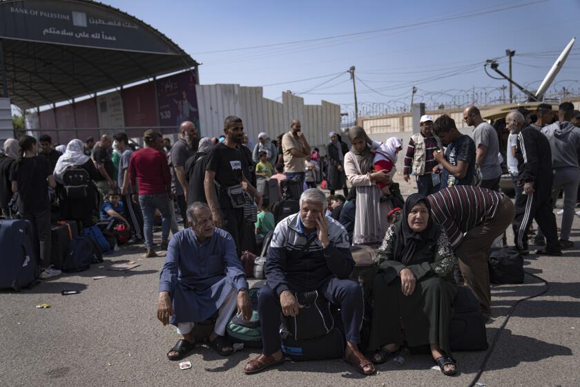 FILE - Palestinians wait to cross into Egypt at the Rafah border crossing in the Gaza Strip on Monday, Oct.16, 2023. As desperate Palestinians in sealed-off Gaza try to find refuge under Israel's relentless bombardment in retaliation for Hamas' brutal Oct. 7 attack, neighboring Egypt and Jordan have replied with staunch refusal, and they have multiple reasons for rejecting the idea. (AP Photo/Fatima Shbair, File)