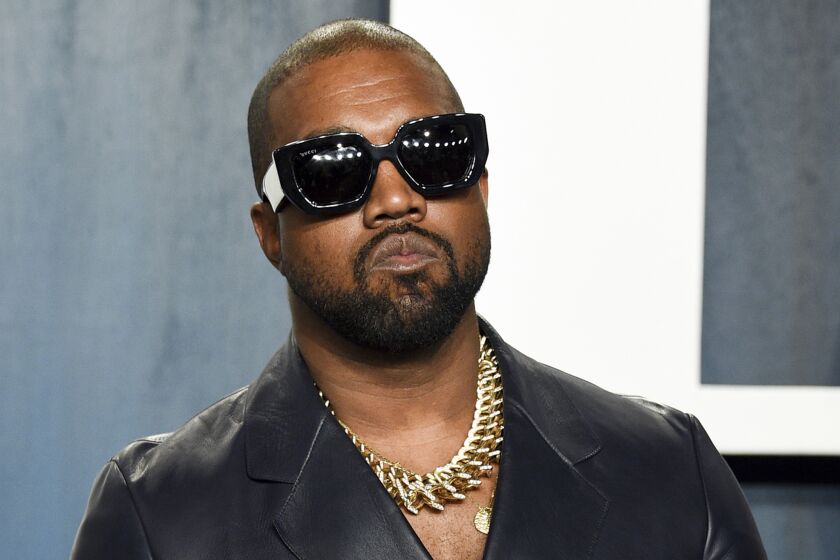 Kanye West posing in sunglasses and a leather jacket