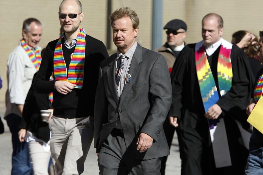 Rev. Frank Schaefer, center, and his son, Tim Schaefer, second from left, walk to a meeting of the Judicial Council of the United Methodist Church, in Memphis, Tenn.