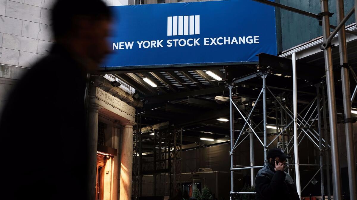 People walk by the New York Stock Exchange.