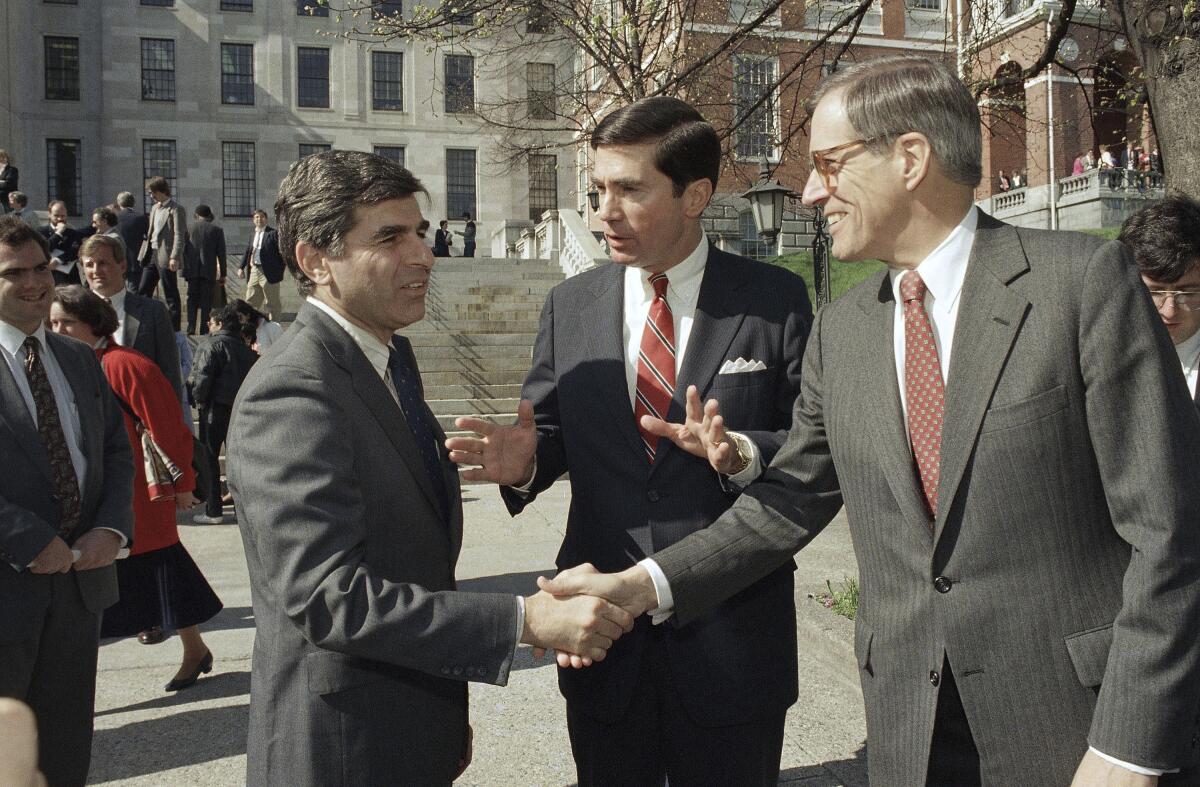 In 1987, Michael Dukakis, left, shakes hands with Pierre Du Pont as Charles S. Robb looks on.