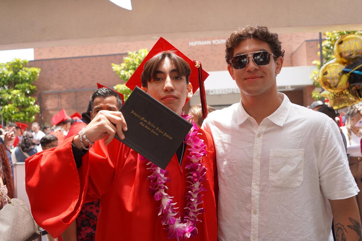 A Back Bay High School graduate Thursday shows off his diploma, following the school's graduation ceremony in Newport Beach.