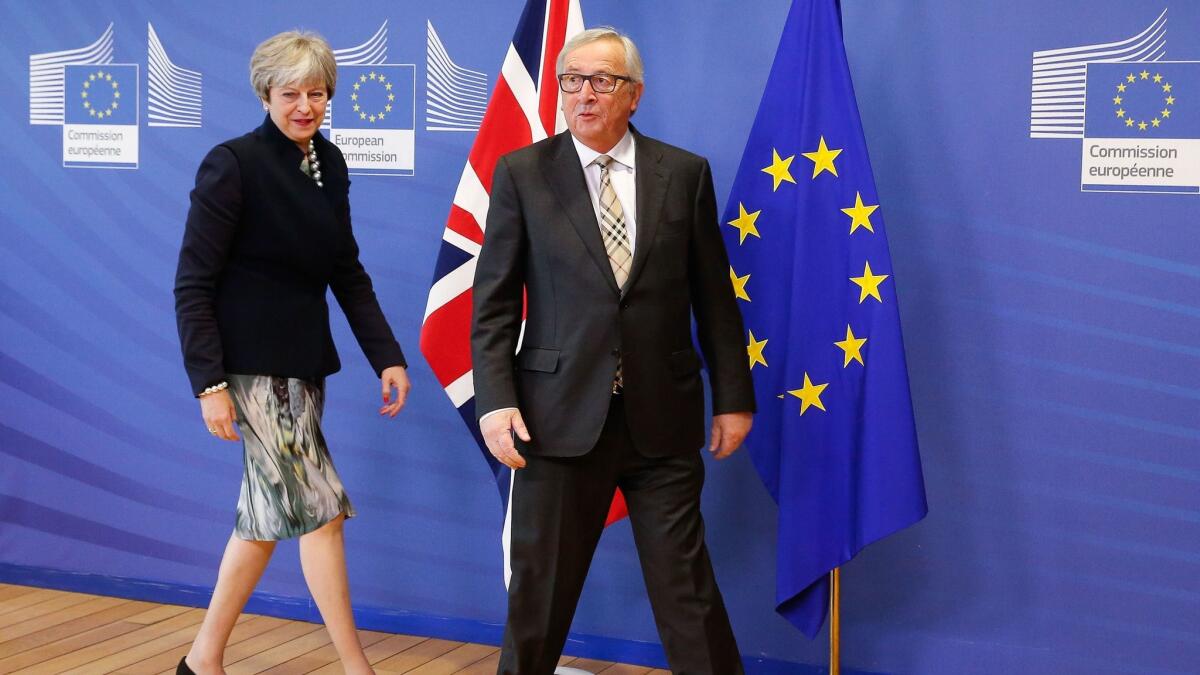 British Prime Minister Theresa May is welcomed by European Commission President Jean-Claude Juncker before a meeting in Brussels on Dec. 4, 2017.
