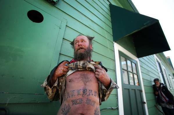 Red Bud, who lives on the streets of Arcata, bares his tattooed torso.