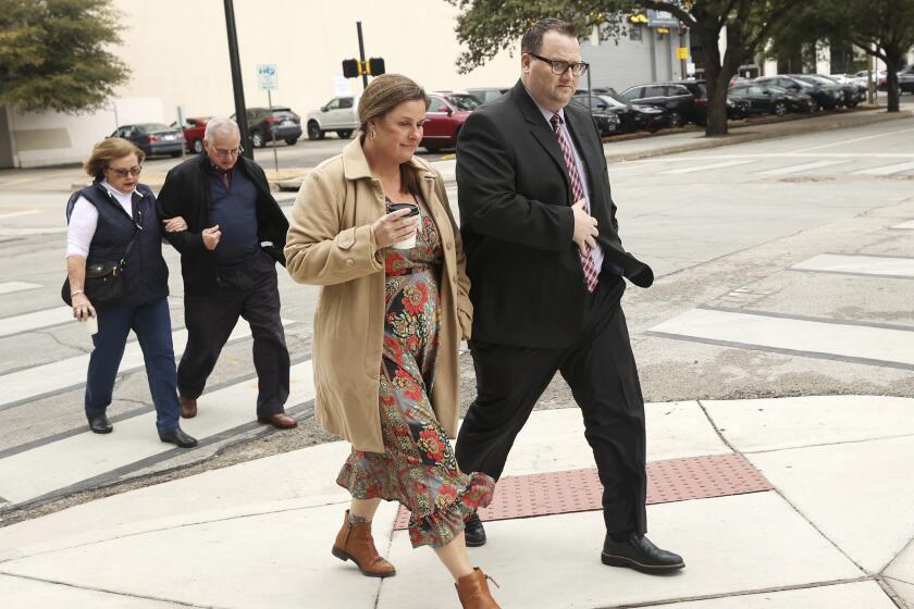 Eric Kay walks to the federal courthouse with family members.