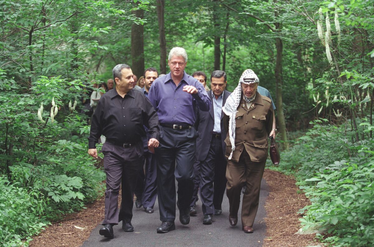 Ehud Barak, Bill Clinton and Yasser Arafat walk together in the documentary "The Human Factor."