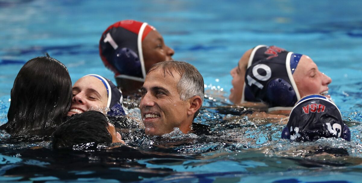 Coach Adam Krikorian celebrates in the pool with U.S. women's water polo team after winning gold in 2021 in Tokyo.